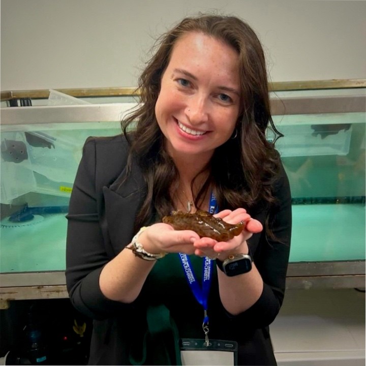 Hannah Yarbrough in the marine research lab at TAMUCC, holding a sea hare specimen